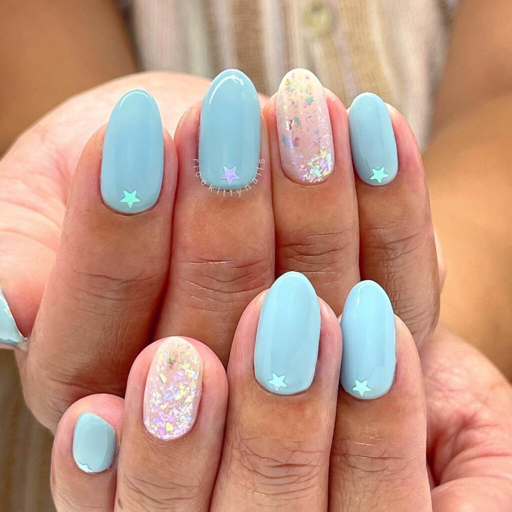 A collection of light blue nails with ombre nail designs, glitter accents, and unique floral patterns showcasing creativity and style.