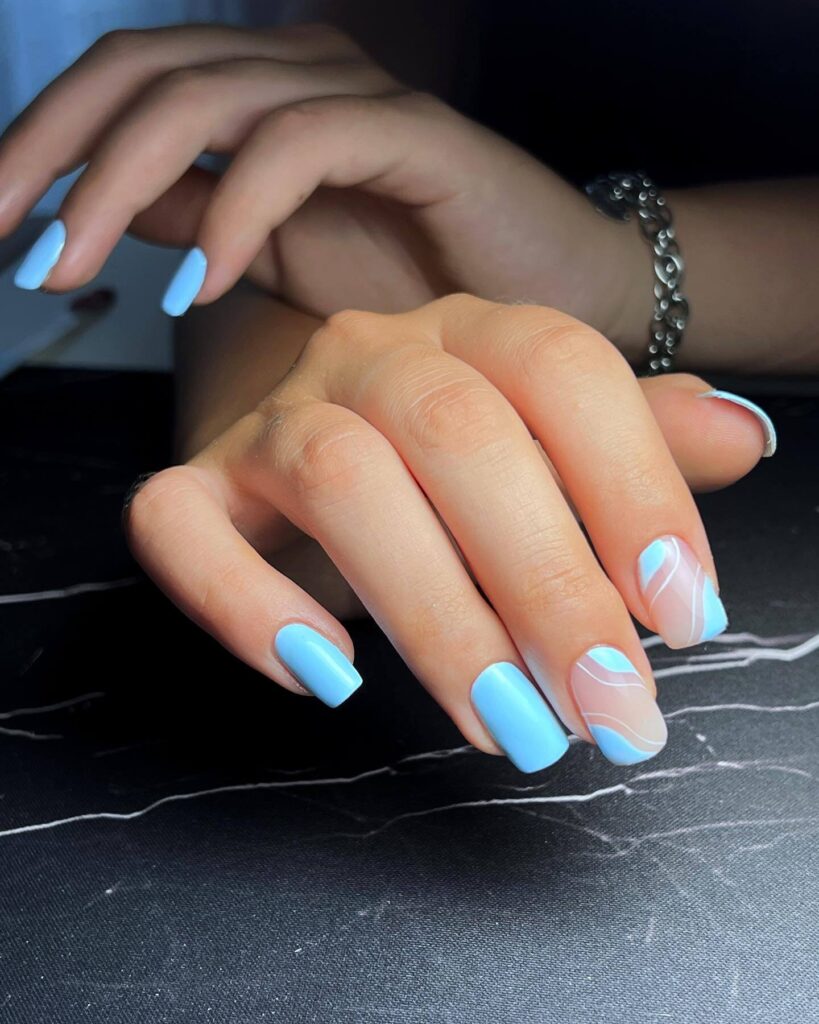 A collection of light blue nails with ombre nail designs, glitter accents, and unique floral patterns showcasing creativity and style.