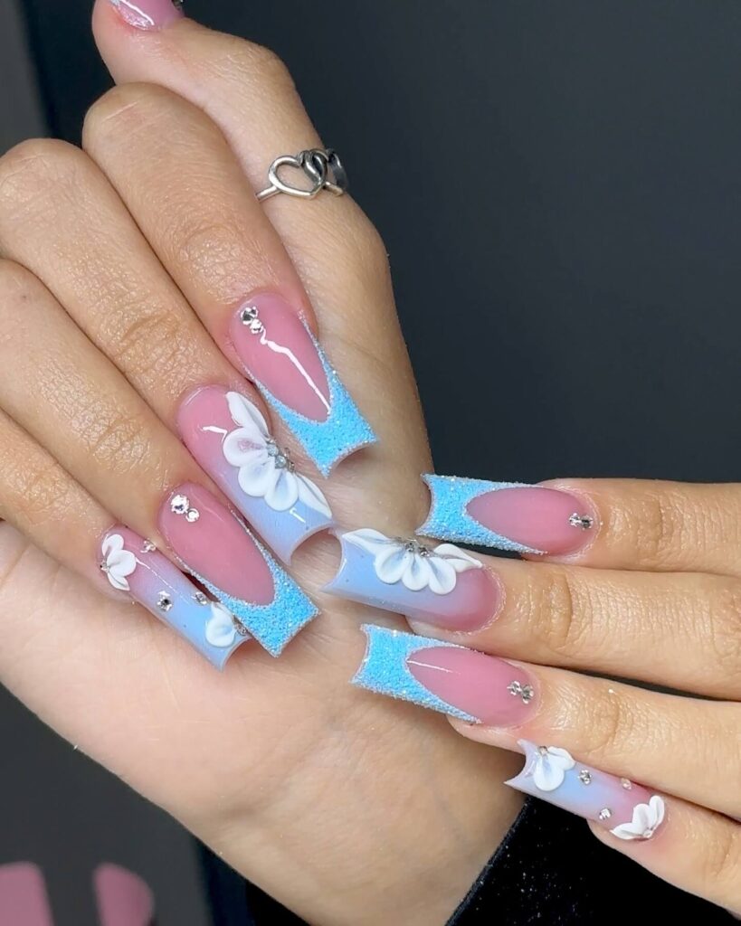 A collection of light blue nails with ombre nail designs, glitter accents, and unique floral patterns showcasing creativity and style.