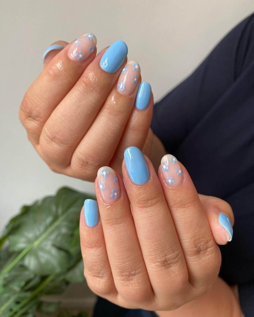 A collection of light blue nails with ombre nail designs, glitter accents, and unique floral patterns showcasing creativity and style.