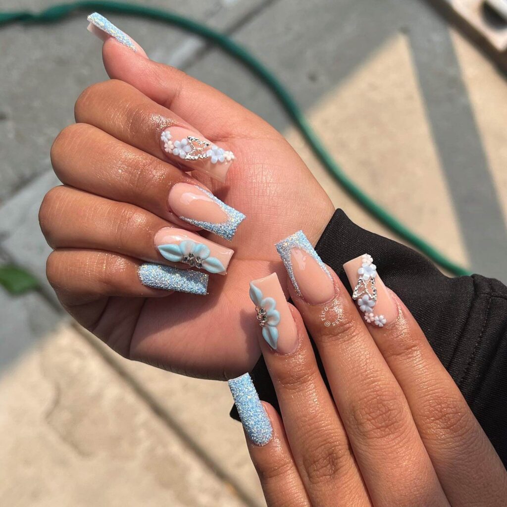 A collection of light blue nails with ombre nail designs, glitter accents, and unique floral patterns showcasing creativity and style.