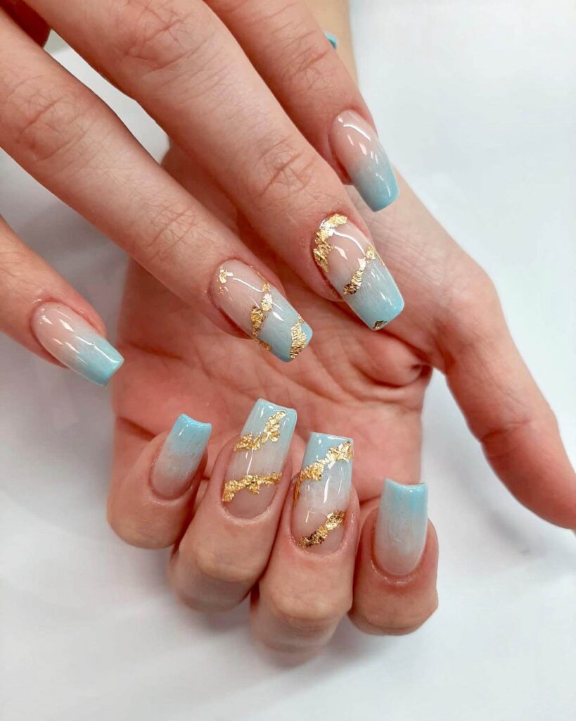 A collection of light blue nails with ombre nail designs, glitter accents, and unique floral patterns showcasing creativity and style.