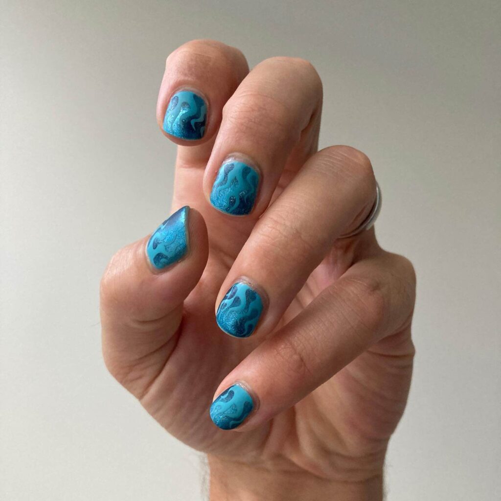 A collection of light blue nails with ombre nail designs, glitter accents, and unique floral patterns showcasing creativity and style.