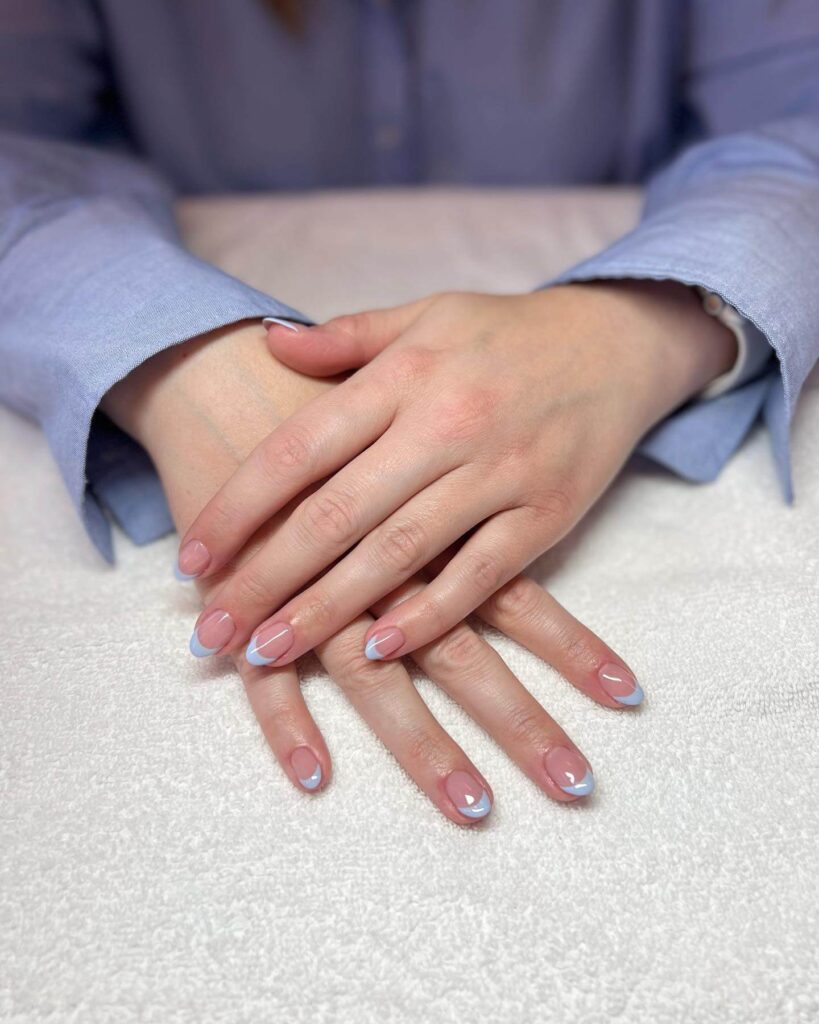 A collection of light blue nails with ombre nail designs, glitter accents, and unique floral patterns showcasing creativity and style.