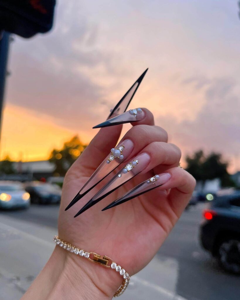 A collection of stiletto nails featuring bold designs, from acrylic and minimalist to glitter and ombre finishes for a dramatic and elegant manicure. 