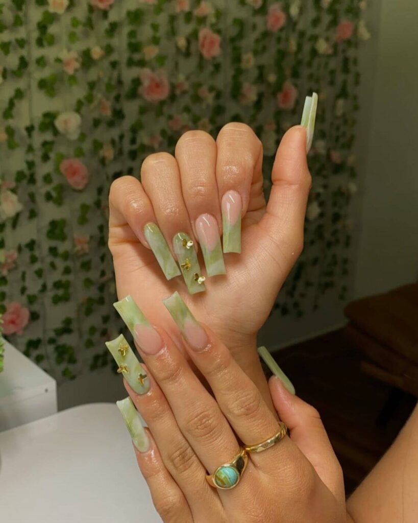 Freshly painted sage green nails with a minimalist design. This muted green nail polish trend is perfect for a subtle, nature-inspired manicure.