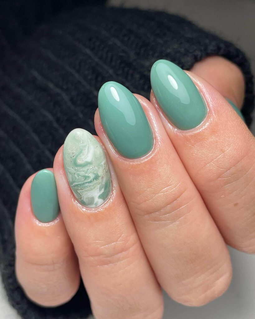 Freshly painted sage green nails with a minimalist design. This muted green nail polish trend is perfect for a subtle, nature-inspired manicure.