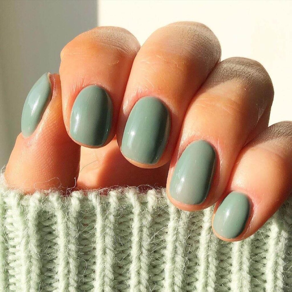 Freshly painted sage green nails with a minimalist design. This muted green nail polish trend is perfect for a subtle, nature-inspired manicure.